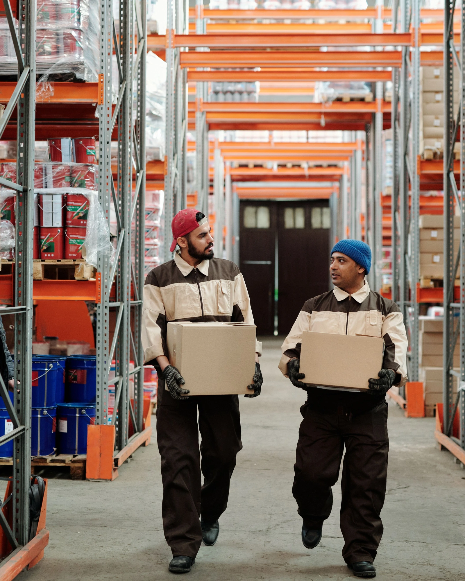 Workers handling cartons in a warehouse aisle